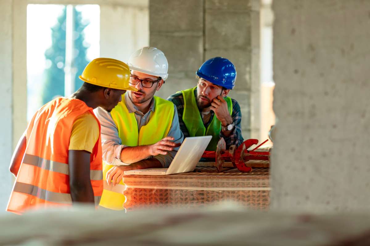 MEA-interpretation-simultanee Interprète sur un chantier qui fait la traduction entre deux autres hommes